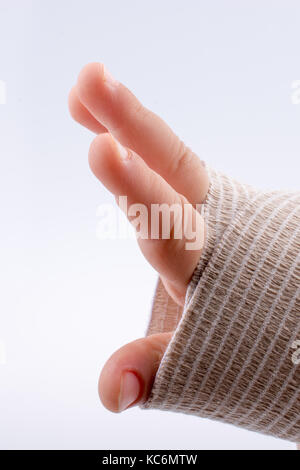 Il polso del bambino avvolto in un bendaggio su sfondo bianco Foto Stock