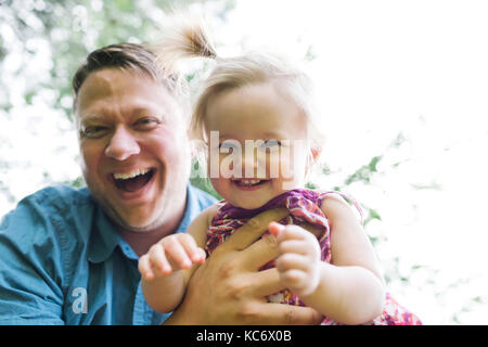 Padre giocare con baby girl (12-17 mesi) nel cortile posteriore Foto Stock