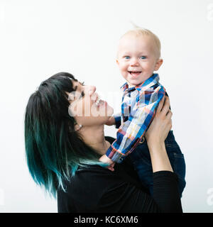 Ritratto di madre figlio di contenimento (12-17 mesi) contro uno sfondo bianco Foto Stock