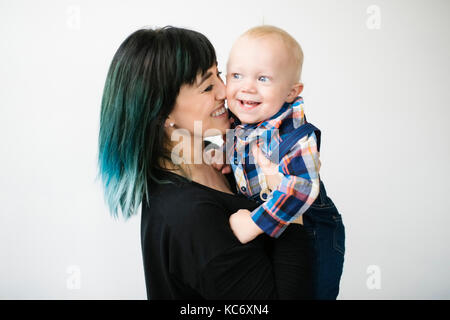 Ritratto di madre figlio di contenimento (12-17 mesi) contro uno sfondo bianco Foto Stock