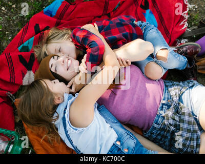 Donna con figlio (6-7) e la figlia (8-9) giacente su una coperta Foto Stock
