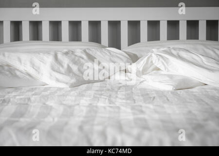 La camera da letto bianco ha una coperta accartocciata. confuso concetto di letto. Foto Stock