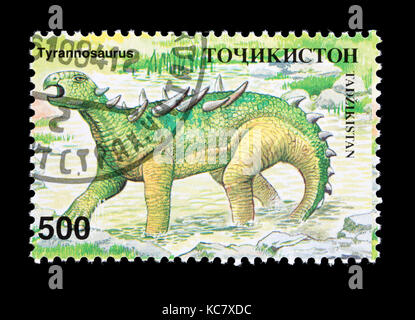 Francobollo dal Tagikistan raffigurante un dinosauro. Foto Stock