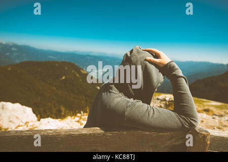 Premuto triste donna in alta montagna viewpoint. persona di sesso femminile in felpa con cappuccio a pensare a problemi nella vita. nei toni dell'immagine. Foto Stock
