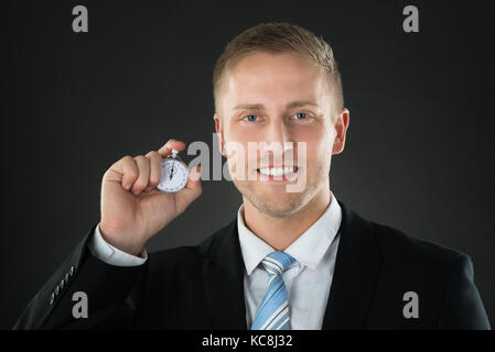 Ritratto di un imprenditore tenendo il cronometro in mano Foto Stock