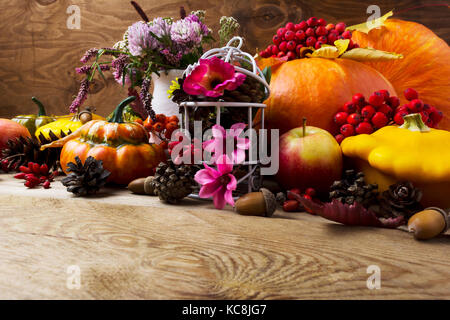 Rientrano nella tabella centrotavola con zucche, verdure, rowan bacche e fiori di colore rosa decorata birdcage, spazio di copia Foto Stock