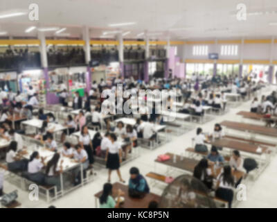 Immagine della sfuocatura mensa sala da pranzo Camera, un sacco di persone che vengono a mangiare cibo in mensa universitaria blur sullo sfondo Foto Stock