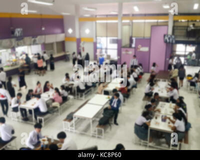 Immagine della sfuocatura mensa sala da pranzo Camera, un sacco di persone che vengono a mangiare cibo in mensa universitaria blur sullo sfondo Foto Stock