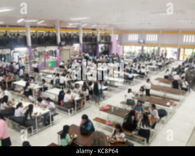 Immagine della sfuocatura mensa sala da pranzo Camera, un sacco di persone che vengono a mangiare cibo in mensa universitaria blur sullo sfondo Foto Stock