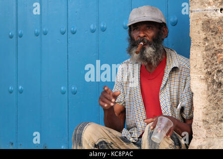 L'AVANA, CUBA, 15 FEBBRAIO 2014 : l'uomo anziano fuma il sigaro in strada. I sigari sono un prodotto cubano famoso in tutto il mondo e quasi tutta la produzione è Foto Stock