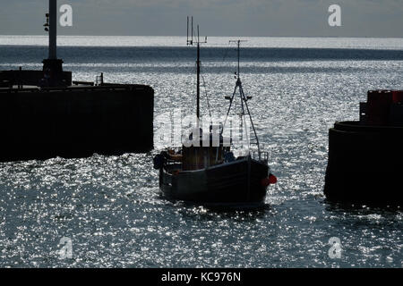 Barca da pesca in silhouette entrando in porto di Bridlington. Foto Stock