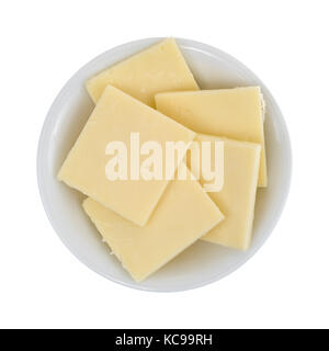 Vista dall'alto di una piccola ciotola riempita con formaggio Cheddar forte fette quadrate isolate su uno sfondo bianco. Foto Stock