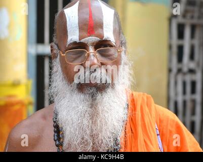 Old Vaishnavite Brahmin (prete indù che adorava Vishnu) con lunga barba bianca e elaborata urdhva pundra sulla fronte, indossando un vestito arancione Foto Stock