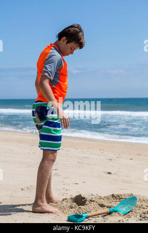 Avon, Outer Banks, North Carolina, Stati Uniti d'America. Giovane ragazzo in piedi sulla spiaggia. Foto Stock