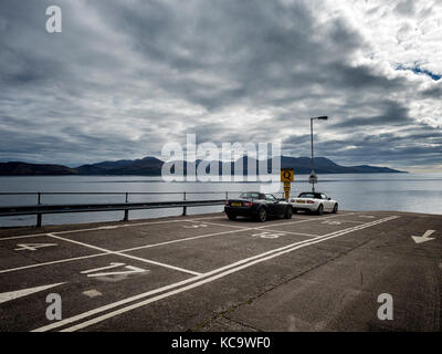 Due Mazda MX-5 auto sportive di attendere presso il terminale CalMac a Claonaig, penisola di Kintyre, per il traghetto per Lochranza sull'isola di Arran (fondo) Foto Stock