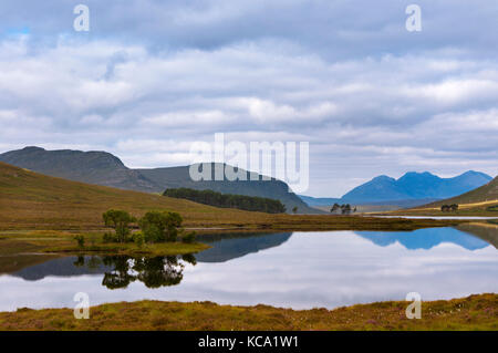 Il bellissimo lago con riflessi di alberi e le montagne circostanti nelle highlands scozzesi, in scontland, Regno Unito; concetto per il viaggio in Foto Stock