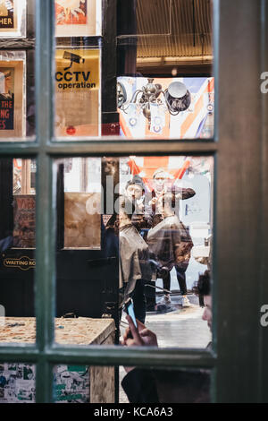 Uomo di ottenere un taglio di capelli all'interno Hobbs Barbieri, Barber shop situato all'interno di Borough Market, uno dei più grandi e più antiche i mercati alimentari a Londra. Foto Stock