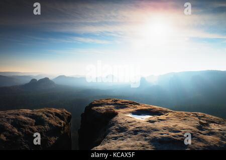 Molla blu alba. scogliera di arenaria al di sopra di una profonda valle misty in Sassonia svizzera. picchi collinare fuori dalla nebbia sreamy. Foto Stock