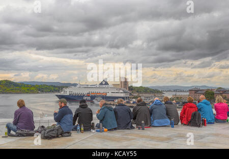 Rilassante ai turisti di ammirare la vista dell'Oslofjord dal teatro dell'Opera di Oslo tetto, home nazionale norvegese Opera e Balletto. Foto Stock