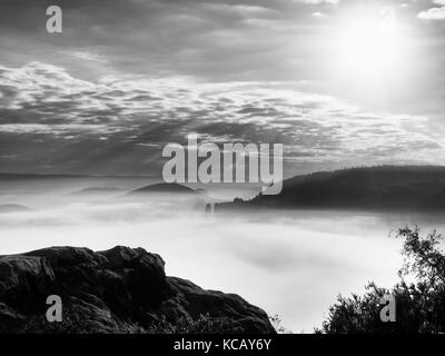 Esposti rupe di arenaria al di sopra di una profonda valle misty alla fine dell'estate. dreamy umore entro lo spuntar del giorno dopo la notte di tempesta. Foto Stock