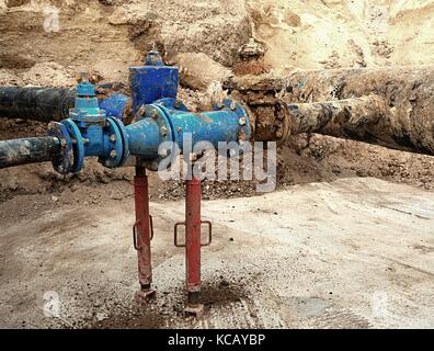 Antico e grande bere acqua tubi raccordati con nuovo blu le valvole a saracinesca e riduzione membri congiuntamente. Terminata la riparazione in attesa di tubazioni per la copertura da creta. extreme Foto Stock