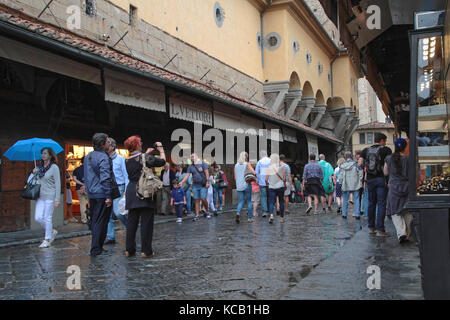 FIRENZE, ITALIA, 13 settembre 2015 : turisti sotto la pioggia su Ponte Vecchio. Firenze era un centro del commercio e della finanza medievale, ed è considerata la sua Foto Stock