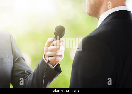 Close-up di un reporter intervista del conduttore di imprenditore Foto Stock