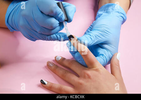 Manicurist chiodi di verniciatura con vernice. Foto Stock