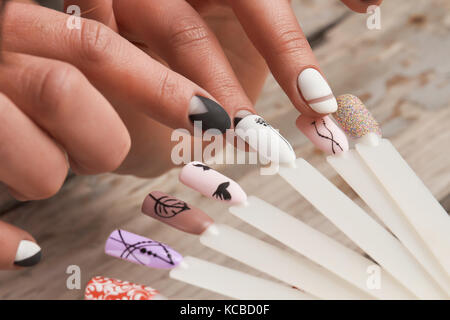 Donna in manicure scegliendo nail design. Foto Stock