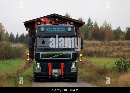 Salo, Finlandia - 30 settembre 2017: VOLVO FM semi di tauno salminen trasporta una cabina di legno lungo la strada di campagna nel sud della Finlandia in autunno. Foto Stock