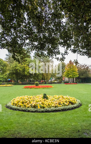 Abbey Gardens Winchester Hampshire. Piccolo e tranquillo parco dotato di attrezzature per il gioco e panchine in mezzo alle aiuole, zone erbose e un flusso. Foto Stock