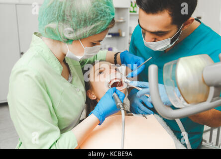 Bella ragazza sui denti preventiva pulizia al tirocinante dentista. Foto Stock