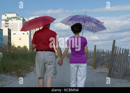 Coppia senior con ombrelloni a Myrtle Beach SC, Stati Uniti d'America. Foto Stock