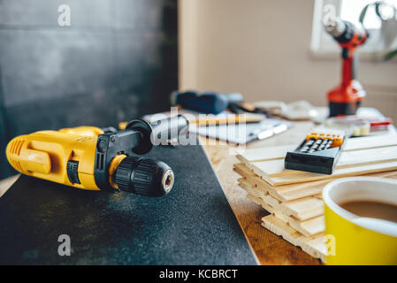 Punte di perforazione e punte di perforazione gialle sul tavolo con altri attrezzi Foto Stock