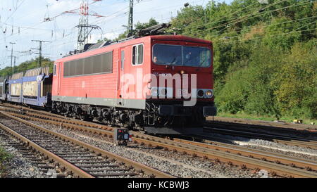 Classe DB 155 locomotore elettrico con manifesto misti carri presso Koln-Gremberg, Germania Foto Stock