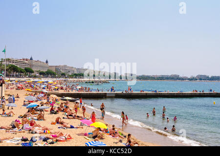 Vacanzieri godere del bel tempo sulla spiaggia pubblica - CANNES, Francia Foto Stock