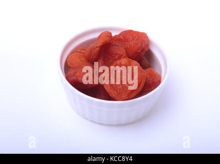Deliziosa organico essiccato di albicocche sul recipiente isolato su sfondo bianco Foto Stock