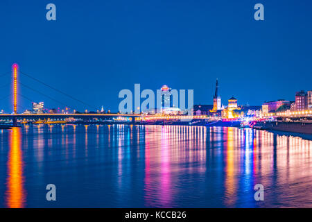 Dusseldorf, Germania. Accesa vecchi edifici storici di notte di promenade area e riflessi colorati nel fiume Reno a Dusseldorf, Germania. Foto Stock