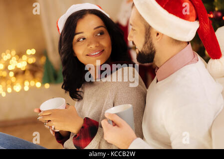 Bella donna guardando suo marito admiringly sul Natale Foto Stock