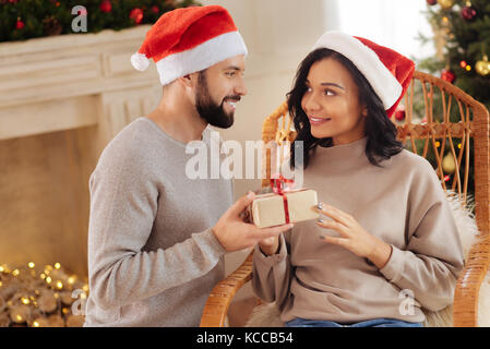 Amorevole marito natale dando presente a sua moglie Foto Stock