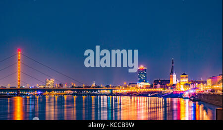 Dusseldorf, Germania. Accesa vecchi edifici storici di notte di promenade area e riflessi colorati nel fiume Reno a Dusseldorf, Germania. Foto Stock