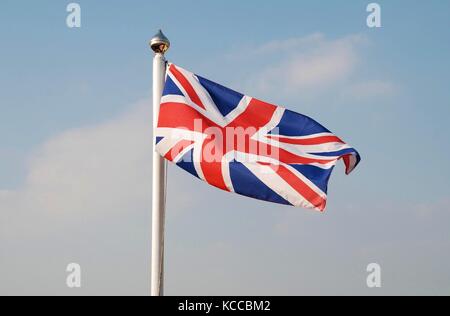 La union jack, bandiera nazionale del Regno Unito, a volare su un pennone a Camber Sands in east sussex, Inghilterra. Foto Stock