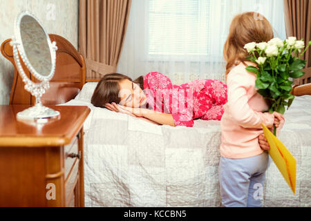 La bambina si congratula con sua madre per la sua festa della mamma Foto Stock