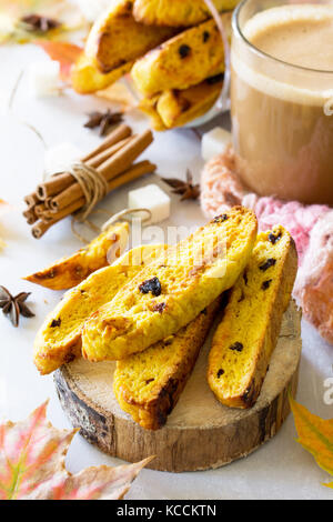 Pane appena sfornato uvetta e cannella biscotti e una tazza di caffè cappuccino su una cucina un tavolo di legno. Foto Stock