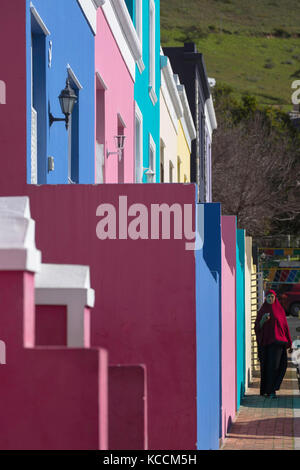 Donna musulmana passato a piedi case colorate in bo kaap, cape town, Western Cape, Sud Africa Foto Stock