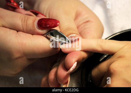 Manicurist a corsi di formazione mostra agli studenti come gestire le unghie con l aiuto del tronchese cuticole prima di applicare la gomma lacca Foto Stock