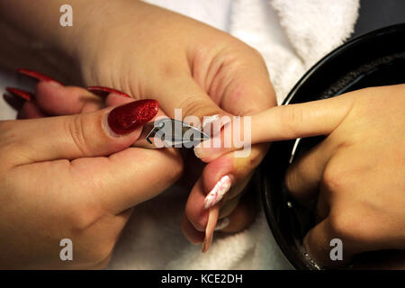 Manicurist a corsi di formazione mostra agli studenti come gestire le unghie con l aiuto del tronchese cuticole prima di applicare la gomma lacca Foto Stock