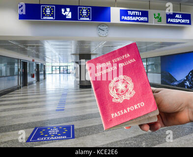 Persona in possesso di passaporto italiano in airport area controllo passaporti, composito digitale Foto Stock