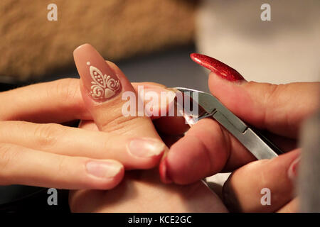 Manicurist a corsi di formazione mostra agli studenti come gestire le unghie con l aiuto del tronchese cuticole prima di applicare la gomma lacca Foto Stock