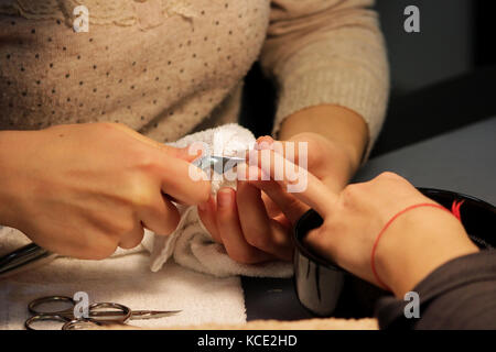 Manicurist a corsi di formazione mostra agli studenti come gestire le unghie con l aiuto del tronchese cuticole prima di applicare la gomma lacca Foto Stock